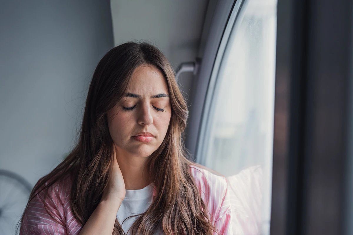 motion-sickness a woman looking uncomfortable while sitting by an airplane window
